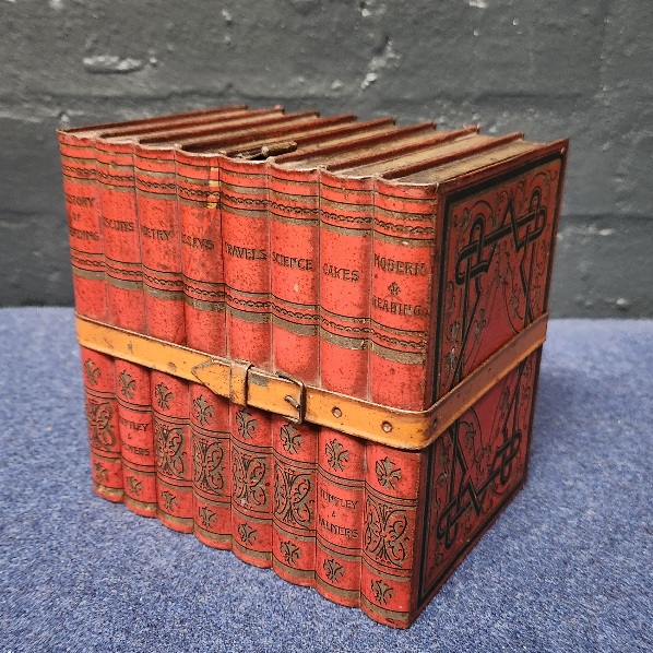 Huntley
                and Palmer biscuit tin in the shape of a bundle of
                books
